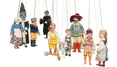 10 unterschiedliche Marionetten vor weißem Hintergrund (Zauberer, ältere Frau, jüngere Frau, Kind, Junge mit Roller, Hund, ...)